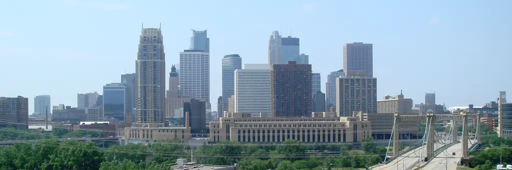 Downtown Minneapolis skyline above the Mississippi River and the Hennepin Avenue Bridge on a summer day