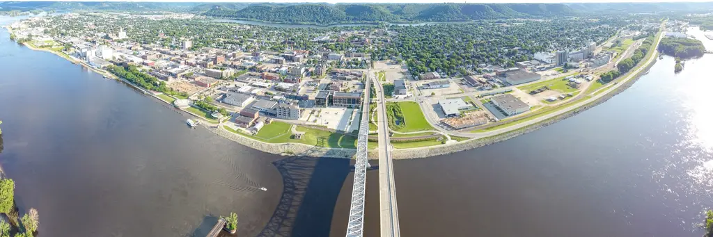 Aerial view of Winona on the Mississippi River with its river bridge and green river bluffs behind the town